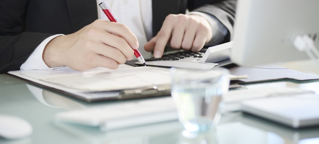 Frau an Schreibtisch mit Stift und Laptop